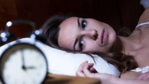 Woman lying awake at night with racing thoughts, insomnia therapy NJ at The CBT Center