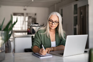 Person journaling and tracking thoughts as part of self-guided CBT, with online CBT therapy NJ resources nearby"